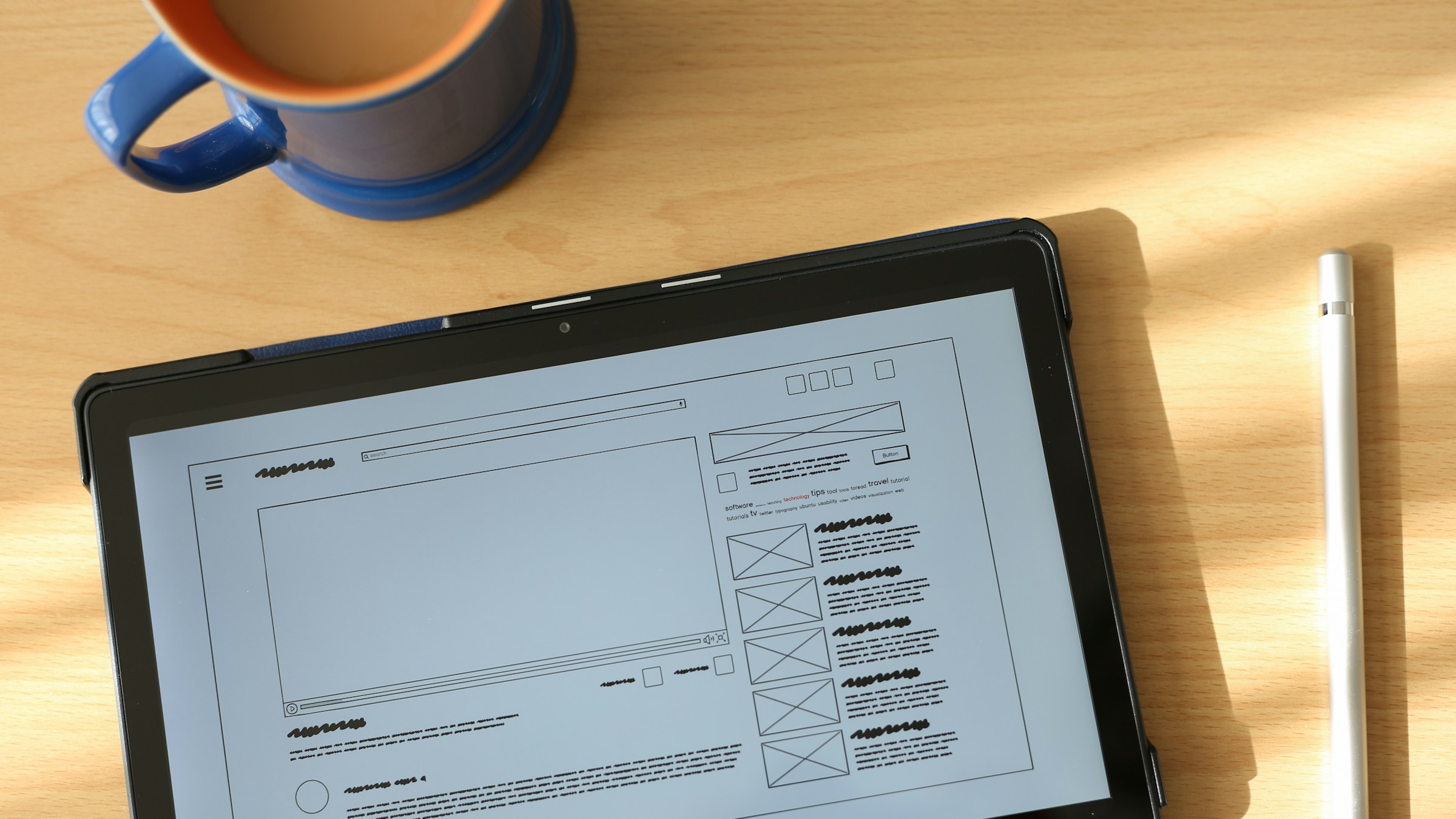 Compact tablet with a bright display and stylus on a desk, illustrating Apple's new OLED iPad mini